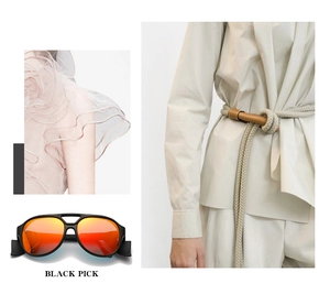 Detail of oversized black sunglasses with orange gradient lenses and a woven rope belt