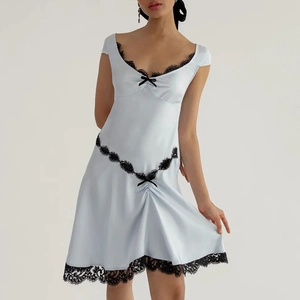 Mini abito in raso bianco con pizzo nero e fiocchi per un look estivo sexy e audace