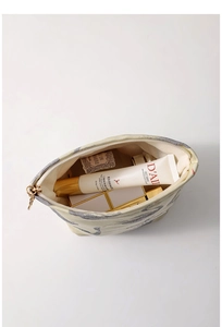 Inside view of swan jacquard cosmetic bag showing capacity for lipsticks and skincare