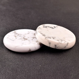 Detailed macro view of two flat white turquoise stone disks with natural grey marble veins