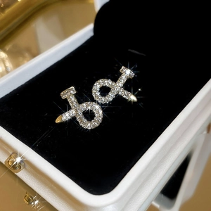 Macro shot of luxury nail-shaped stud earrings with sparkling pavé crystals in gold