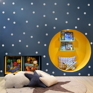 Detailed view of silver dot wall decals arranged on a dark blue wall in a child bedroom