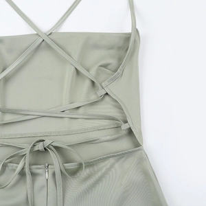 Détail des fines bretelles croisées et de la fermeture éclair invisible sur la robe en satin vert