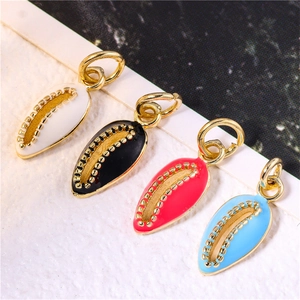 Detail of shell-shaped pendants in four colors with gold plated edges and jump rings