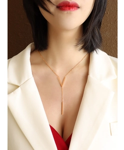 Detailed close-up of a rose gold V-shaped pendant necklace on a female collarbone