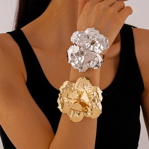 Detailed close-up of metallic irregular flower cuff bracelet with wrinkled texture
