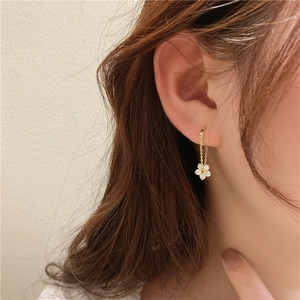 Detailed side view of a gold flower tassel earring with sparkling crystal petals