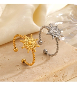 Detail view of 18K gold and silver sun rings on stone tray with twisted band design