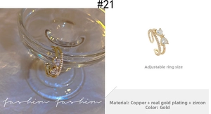 Detail of gold plated bow ring with heart cubic zirconia and adjustable open double band