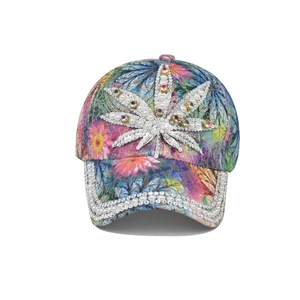 Détail de la casquette avec imprimés feuilles, sequins argentés et perles blanches