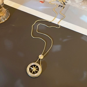 Double-layered geometric gold necklace featuring a sparkling starburst pendant and round coin
