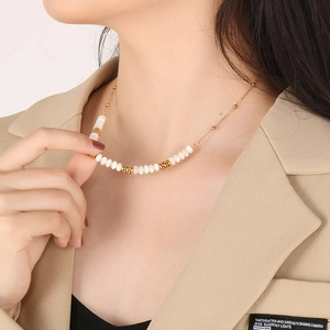 Close-up of elegant gold plated necklace with white pearls on woman's collarbone