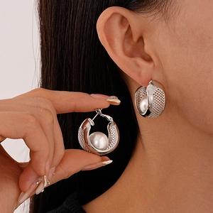 Silver mesh hollow hoop earrings with white pearls shown on a model's ear