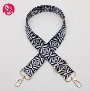 Close-up of adjustable woven shoulder strap with blue geometric diamond patterns and gold hooks