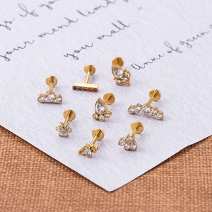 Detailed flat lay of G23 titanium gold labret studs featuring sparkling zircon stones