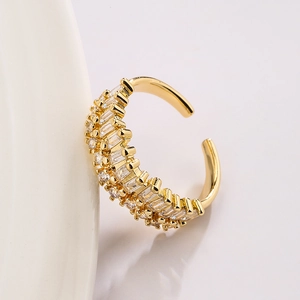 Luxurious gold-plated geometric open ring with sparkling cubic zirconia on white porcelain