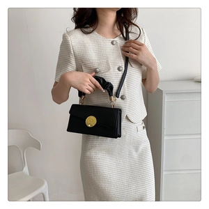 Sac à main en cuir noir avec fermoir doré chic et poignée enveloppée de tissu doux