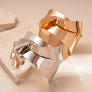 Polished geometric knotted open bangles in gold and silver finish on stone base