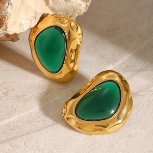 Detailed close-up of gold hammered earrings with translucent green resin stones