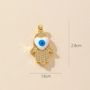Detailed view of gold Hamsa hand pendant with blue evil eye and size 2.8cm x 1.6cm