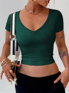 Detail view of the soft green V-neck slim-fit cropped T-shirt fabric and fine stitching