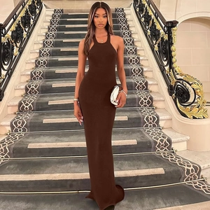 Detailed back view of a brown halter neck knit maxi dress on a grand indoor staircase