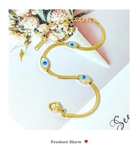 Detail of gold snake chain bracelet with blue evil eye charms and adjustable lobster clasp