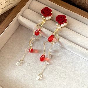 Detail of red flocked rose earrings with pearl fringe and golden water drop charms