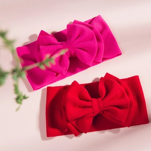 Detail of rose red and red knit baby headbands with large soft double bows