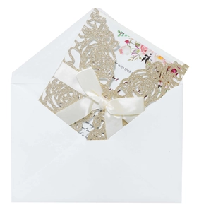 Detail of pink floral glitter laser cut wedding invitation with cream ribbon and envelope