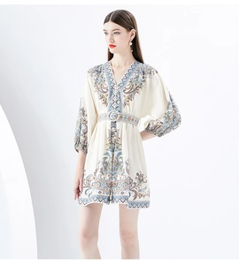 Close-up of V-neckline and lantern sleeves on a vintage print mini dress with waist belt