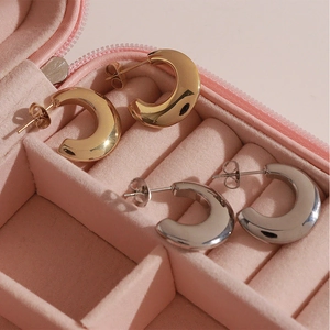 Minimalist C-shaped stud earrings in gold and silver finish displayed in a pink jewelry box