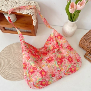 Detailed close-up of a large floral hobo bag on a white table with tulip decor