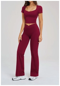 Detail view of the high-waisted flared yoga pants and cropped top in deep red fabric