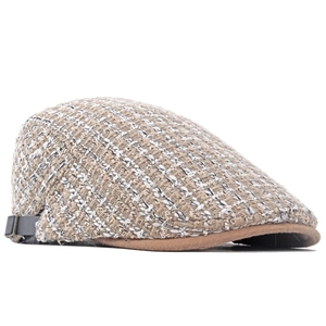 Dettaglio del berretto newsboy in tweed retrò con visiera marrone e cinturino in pelle