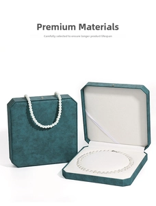 Dettaglio della scatola ottagonale in PU verde scuro con collana di perle bianche interna
