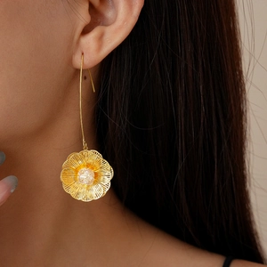 Macro shot of 18K gold plated hollow floral earring with zircon on model ear