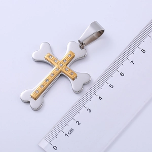 Two-tone stainless steel cross pendant with crystals measuring 5cm on a ruler