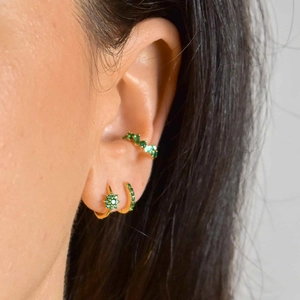 S925 silver needle flower hoop earrings set with green cubic zirconia on a model