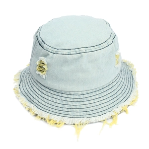Detail of light blue distressed denim bucket hat featuring ripped holes and frayed fringe