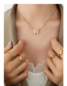 Detail of 18K gold plated butterfly pendant necklace and matching rings on a model