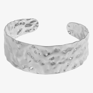 Detailed macro shot of a wide cuff bracelet with a silver hammered texture finish