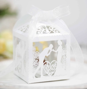Detail of white laser-cut wedding favor box with heart 'Thank You' and ribbon