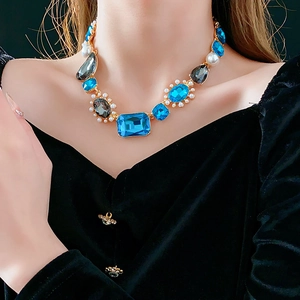Detail of vintage necklace with blue water-drop crystals, pearls, and gold metal base
