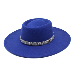 Detailed view of royal blue wool felt hat featuring rhinestone band and metal M logo