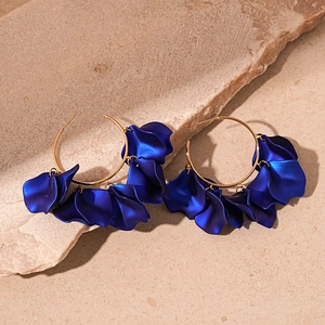 Close-up of vintage hoop earrings with matte dark blue petals and golden alloy ring