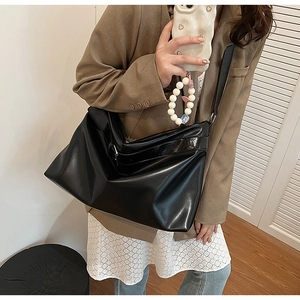 Selfie miroir montrant le drapé et la taille d'un sac cabas minimaliste en cuir PU noir