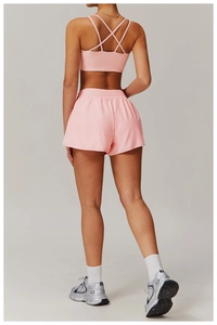 Détail d'un ensemble de sport rose avec soutien-gorge à bretelles croisées et short de course