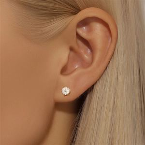 Macro shot of gold S925 sterling silver star stud earring with sparkling zircons on ear
