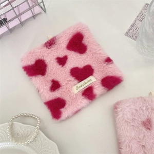 Detailed view of pink plush heart coaster with soft faux fur texture and brand tag